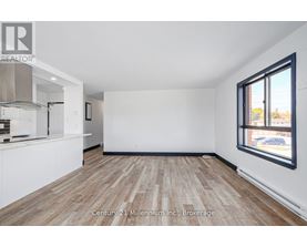 A spacious room with wooden flooring and white walls, ready for a Century 21 Millennium Inc. brokerage listing.