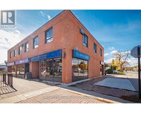 A brick building with a blue sign that says "Century 21 Millennium Inc. Brokerage".