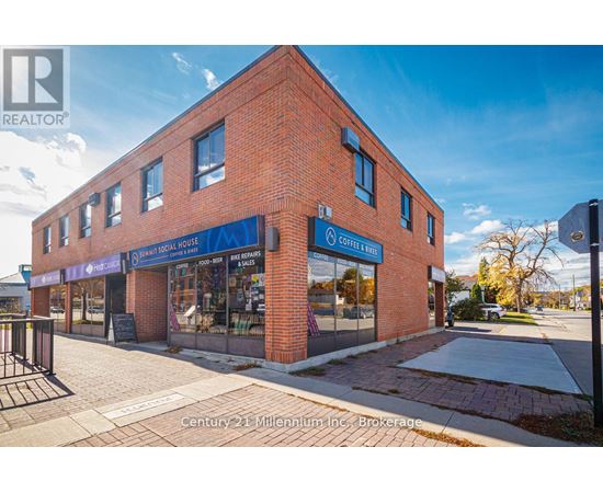 A brick building with a blue sign that says "Century 21 Millennium Inc. Brokerage".