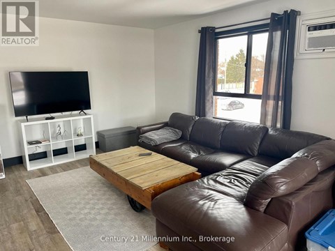 A living room with a brown leather couch and a flat screen TV.