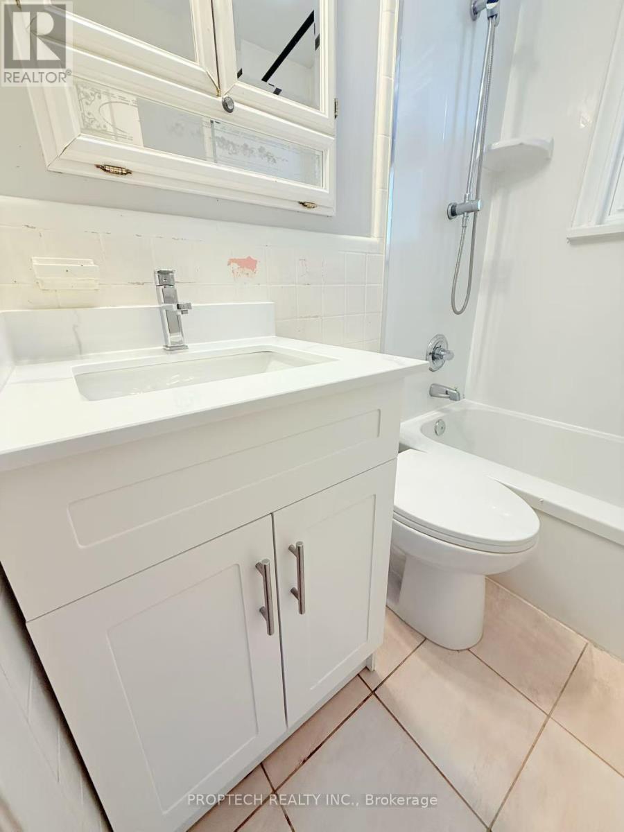 A white bathroom with a sink, toilet and bathtub.