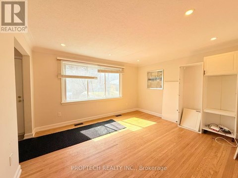 A room with a window and a wooden floor.