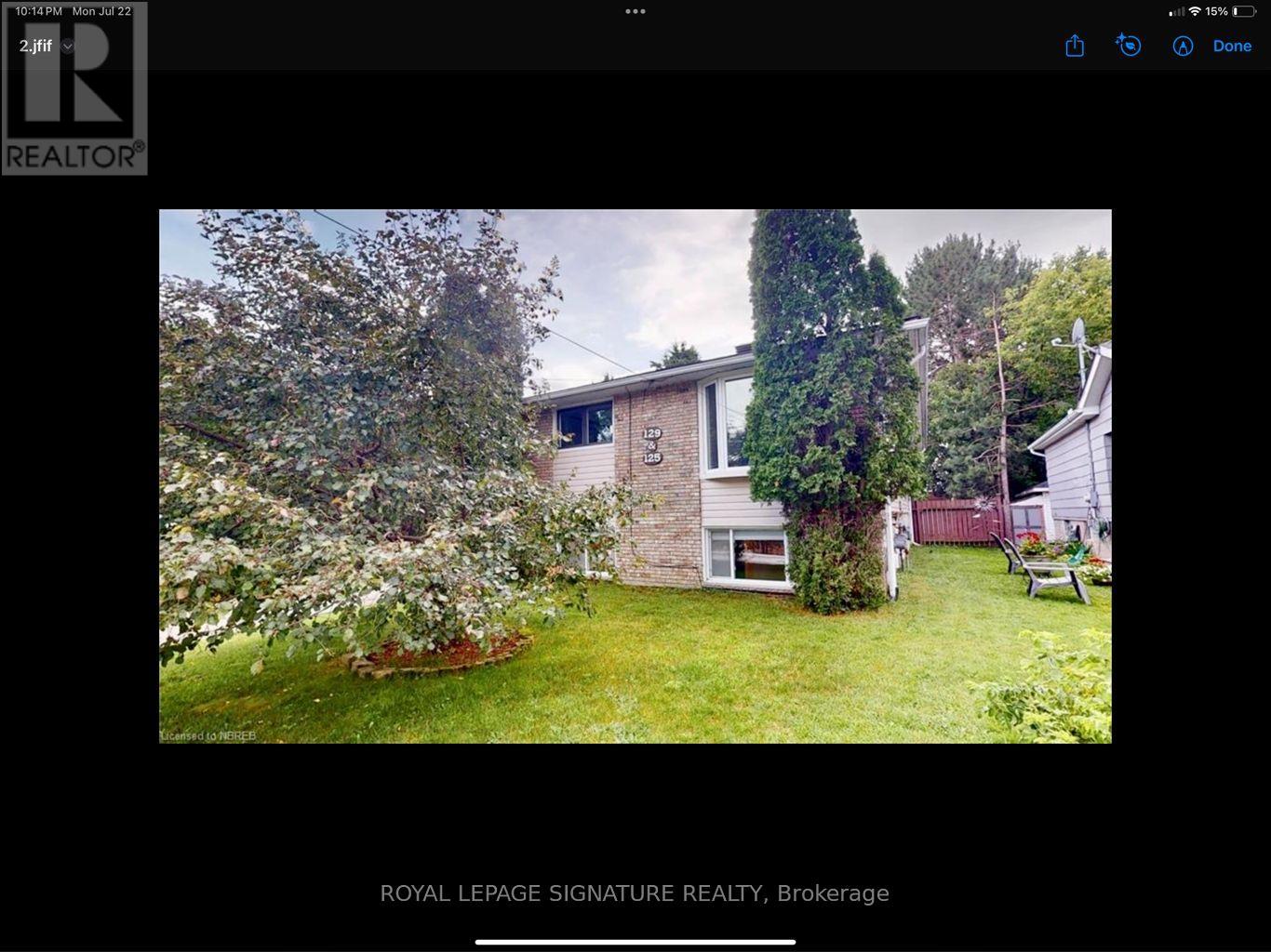 A real estate website shows a photo of a house with a garden.