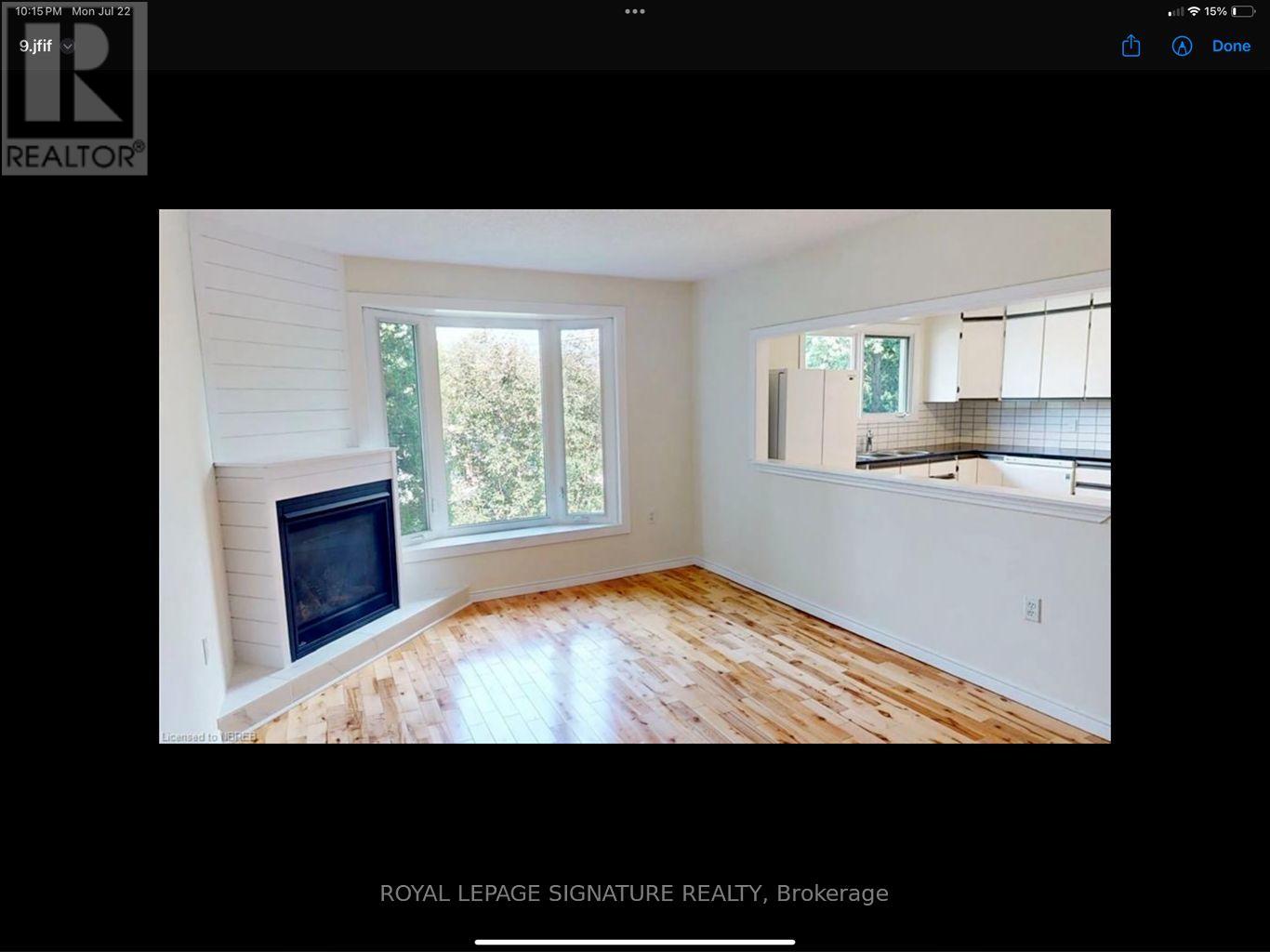 A room with a fireplace and wooden flooring.