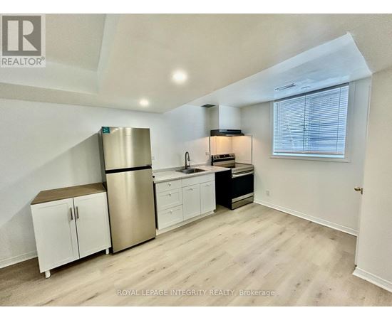 A kitchen with white cabinets and a stainless steel refrigerator.