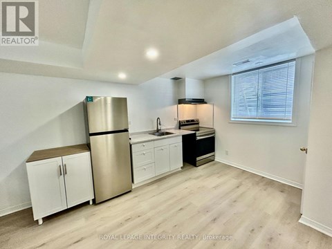 A kitchen with white cabinets and a stainless steel refrigerator.