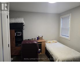 A bedroom with a bed, desk, and chair.