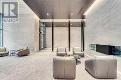 A spacious waiting area with white furniture and a glass wall.