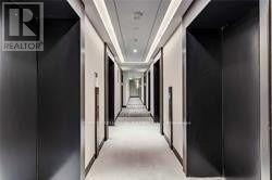 A long hallway with doors on both sides and a REALTOR sign on the wall.