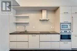 A white kitchen with a sink and an oven.