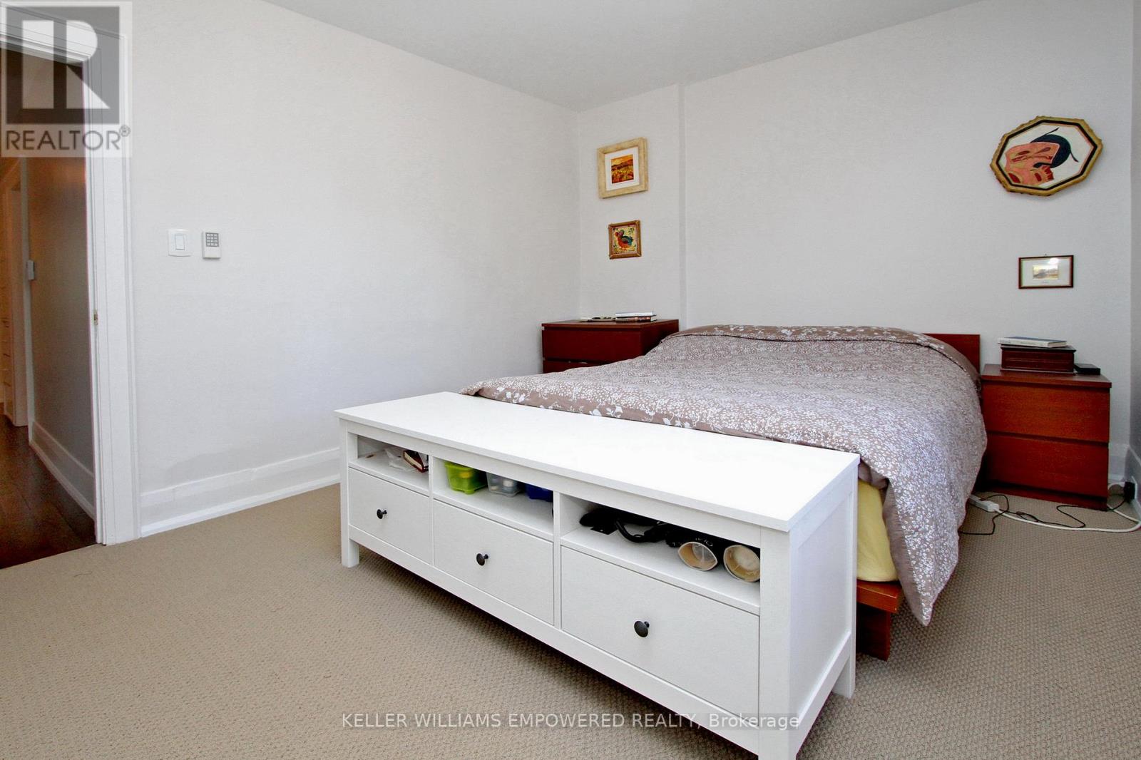A white bed with drawers underneath it in a bedroom.