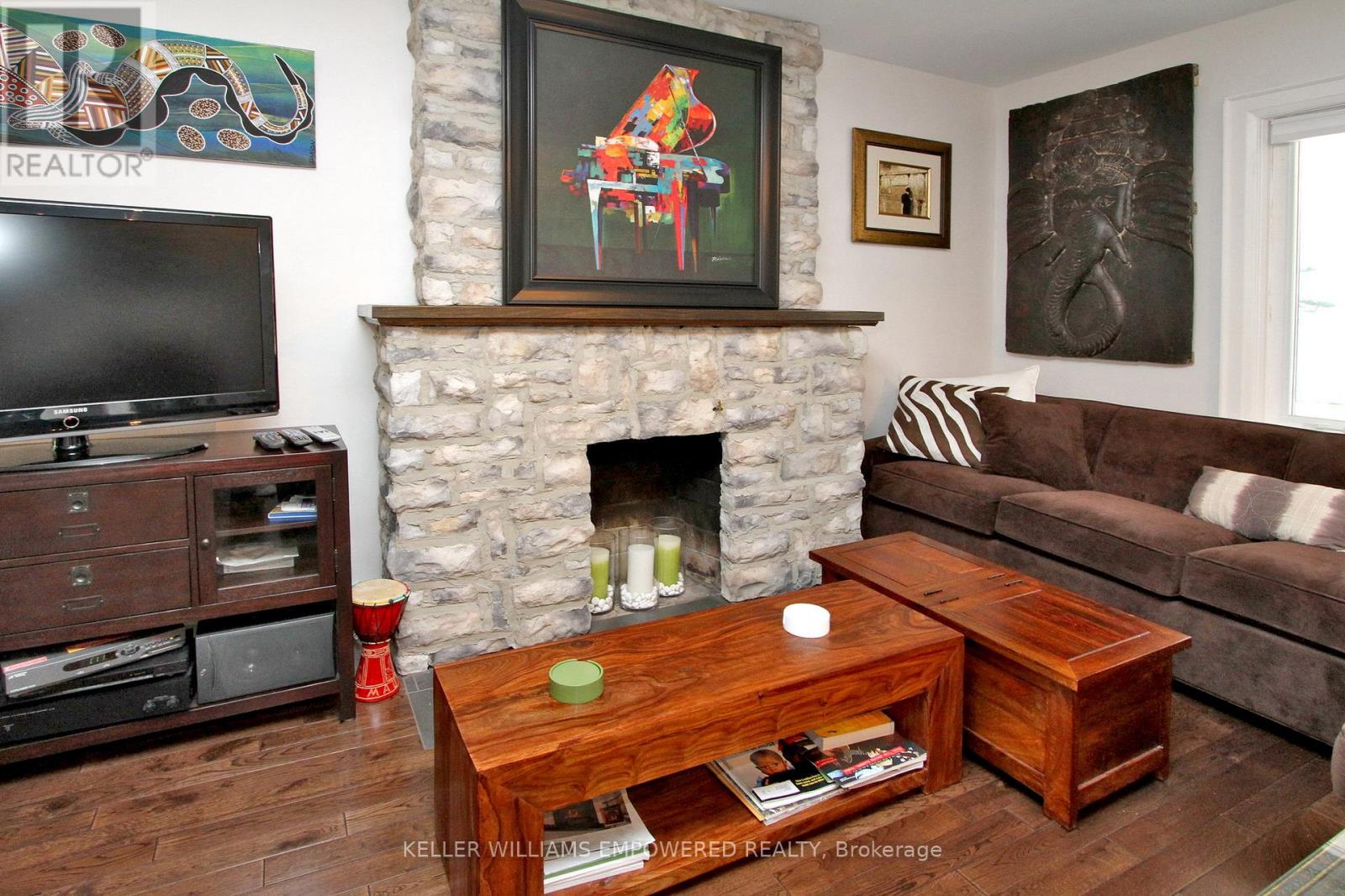 A living room with a fireplace and a painting above it.