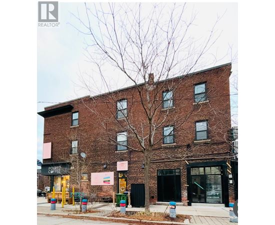 A brick building with a tree in front of it.