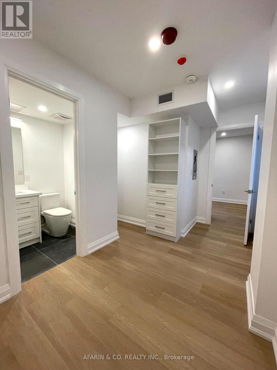 A spacious room with wood flooring and white walls.