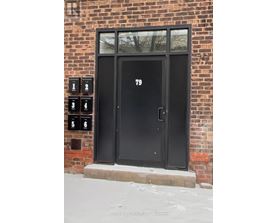 A black door with the number 79 on it.