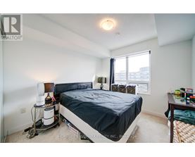 A bedroom with a bed, nightstand, and window.