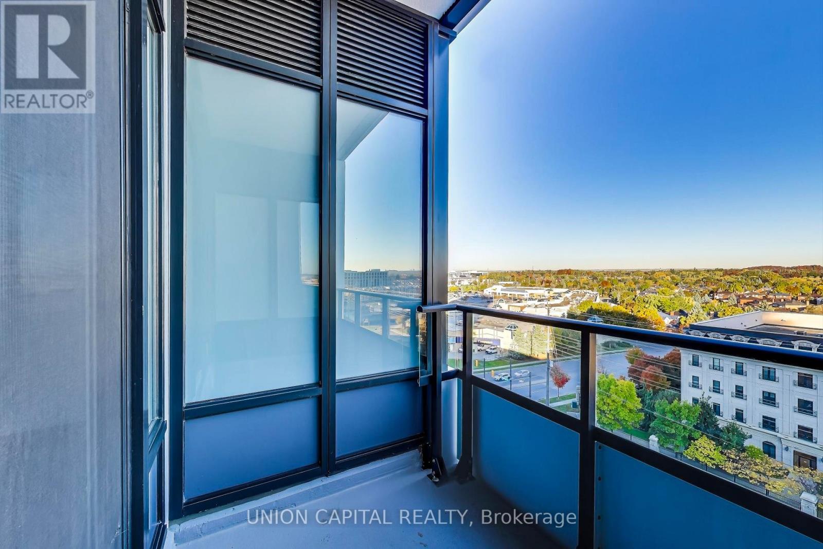 A balcony with a view of the cityscape and a building with the logo "REALTOR" on it.