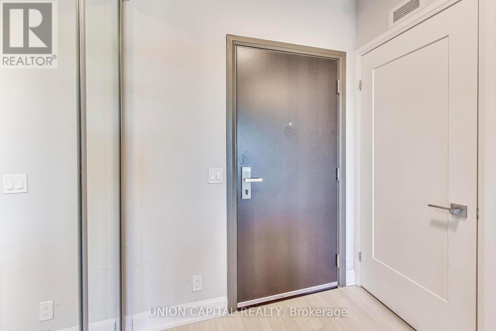 A white door with a silver handle is in a room with white walls.