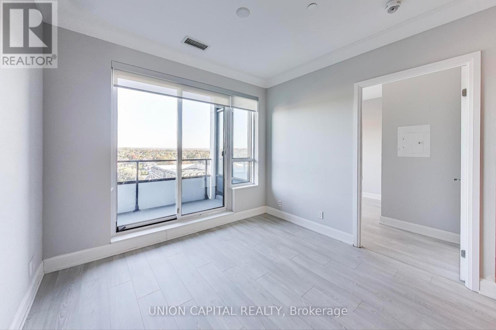 A spacious room with a large window and sliding glass doors.
