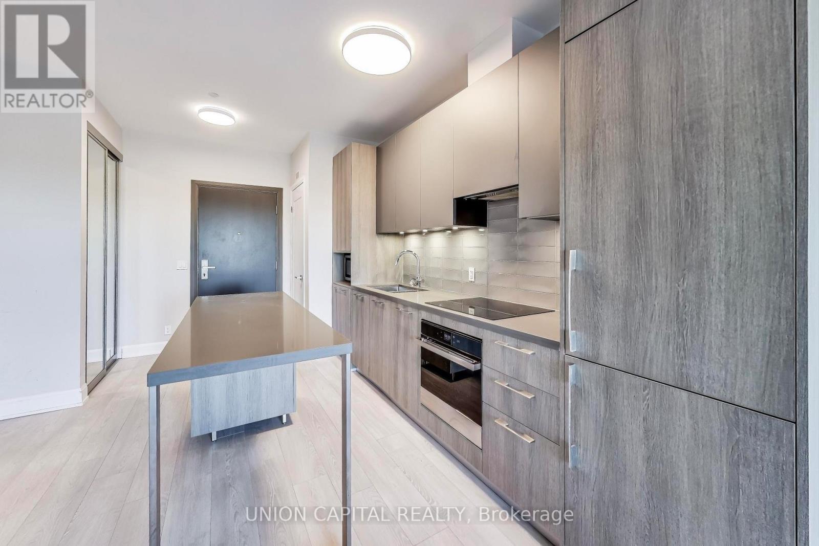 A modern kitchen with a table and stainless steel appliances.