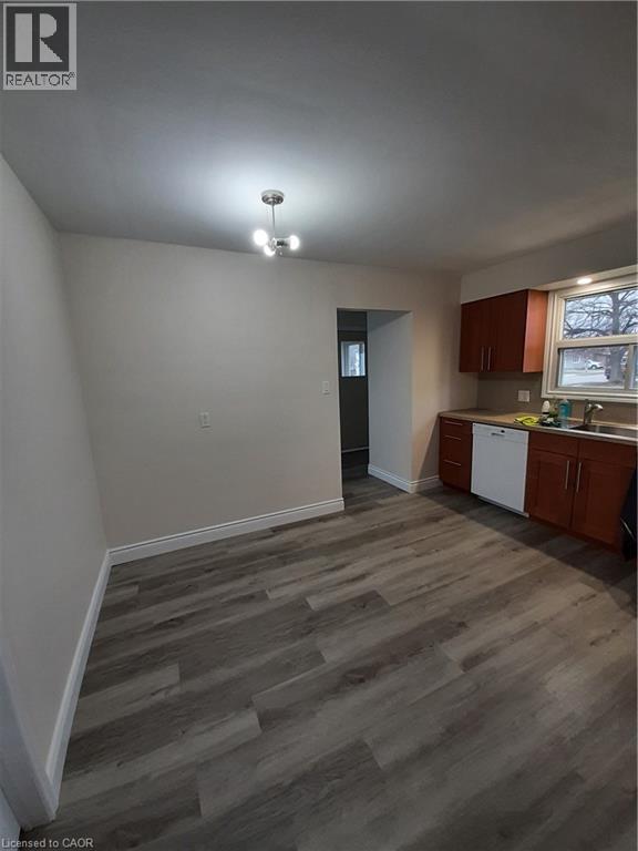 A room with a kitchen area in the background.