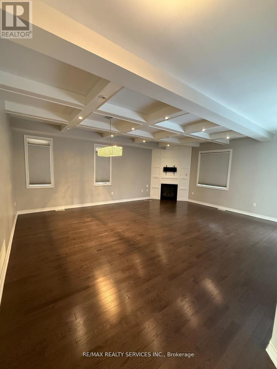 A spacious room with wooden flooring and white walls.