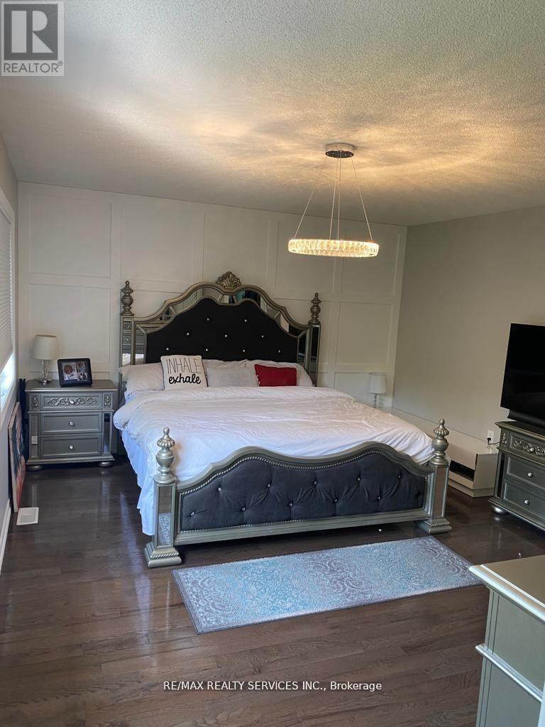 A bedroom with a large bed and a chandelier hanging from the ceiling.