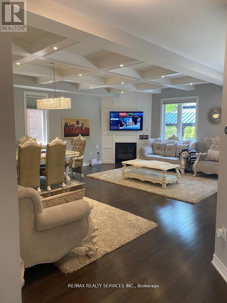A living room with a white couch and a television on the wall.