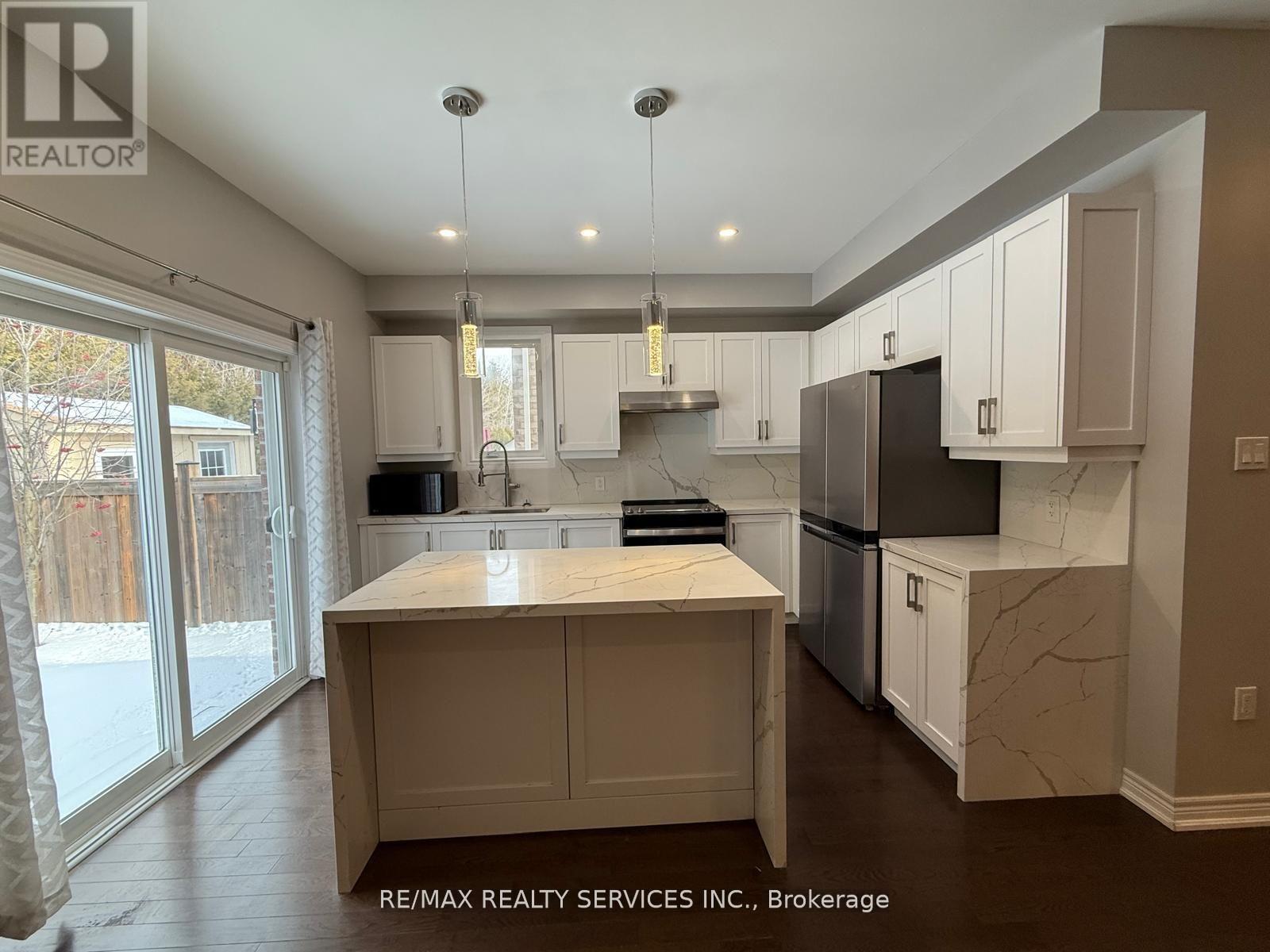 A kitchen with white cabinets and a marble countertop.