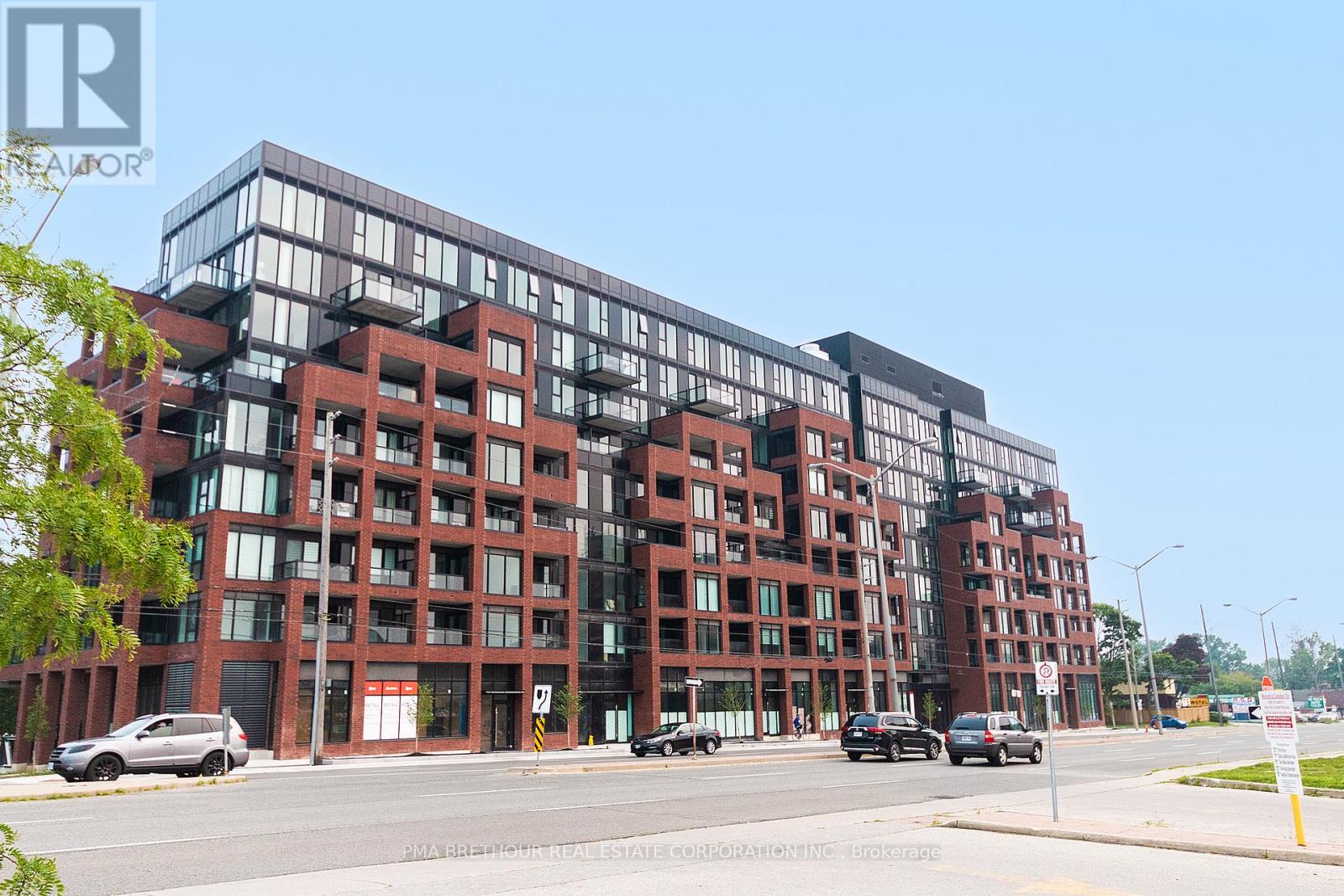 A modern red brick building with glass windows and balconies.