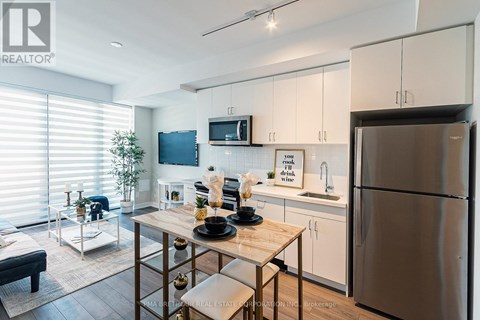 A modern kitchen with a wooden table set for two.