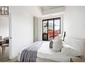 A bedroom with a large bed and a window overlooking a construction site.