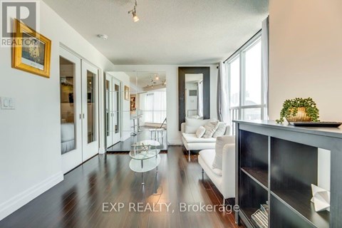 A spacious living room with a white sofa and a glass coffee table.