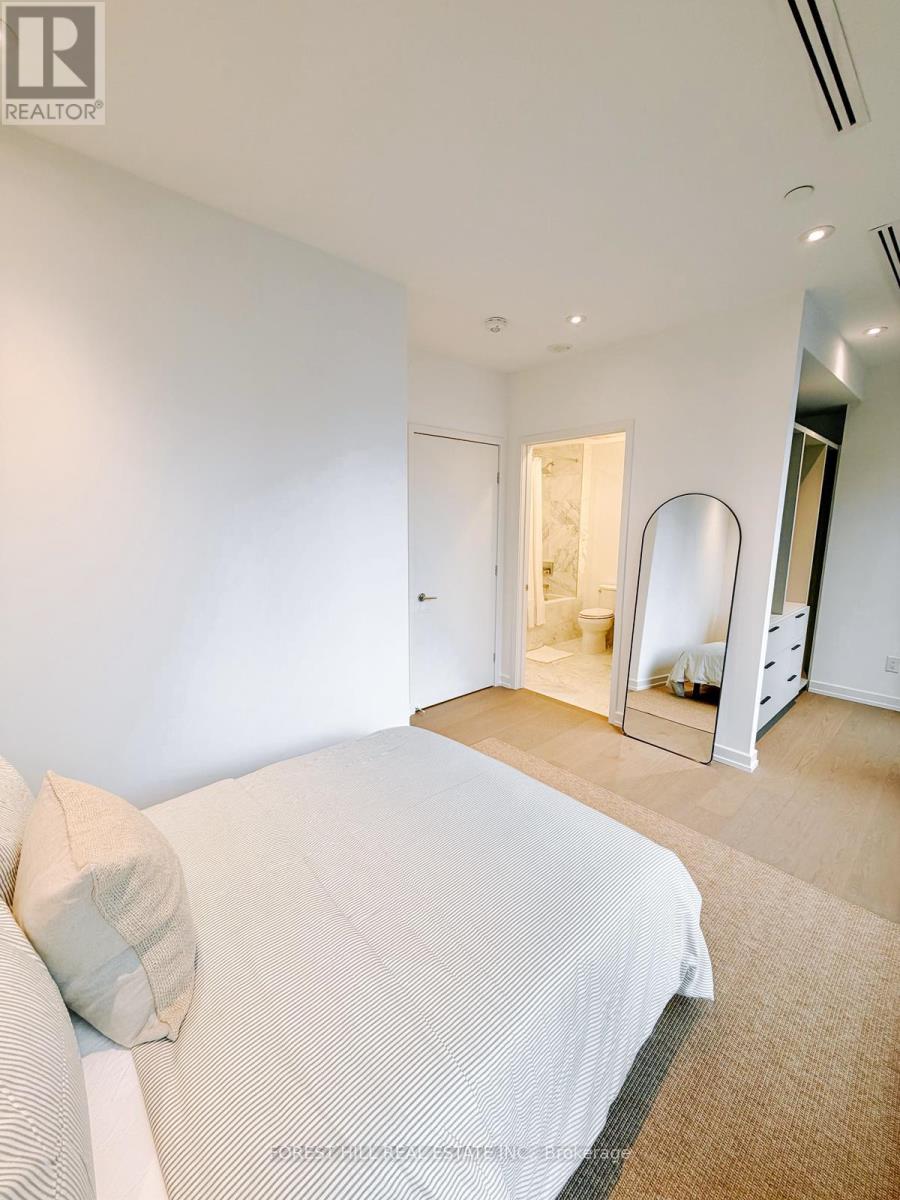 A bedroom with a large bed and a mirrored closet door.