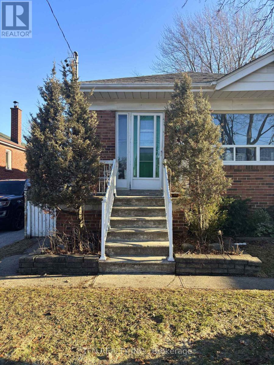 A house with a green door and a white staircase leading to the door.