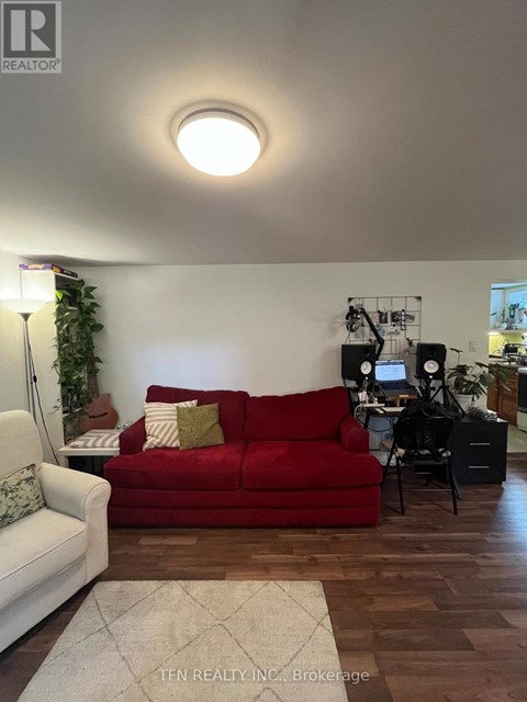 A red couch sits in a living room with a white couch to its left.