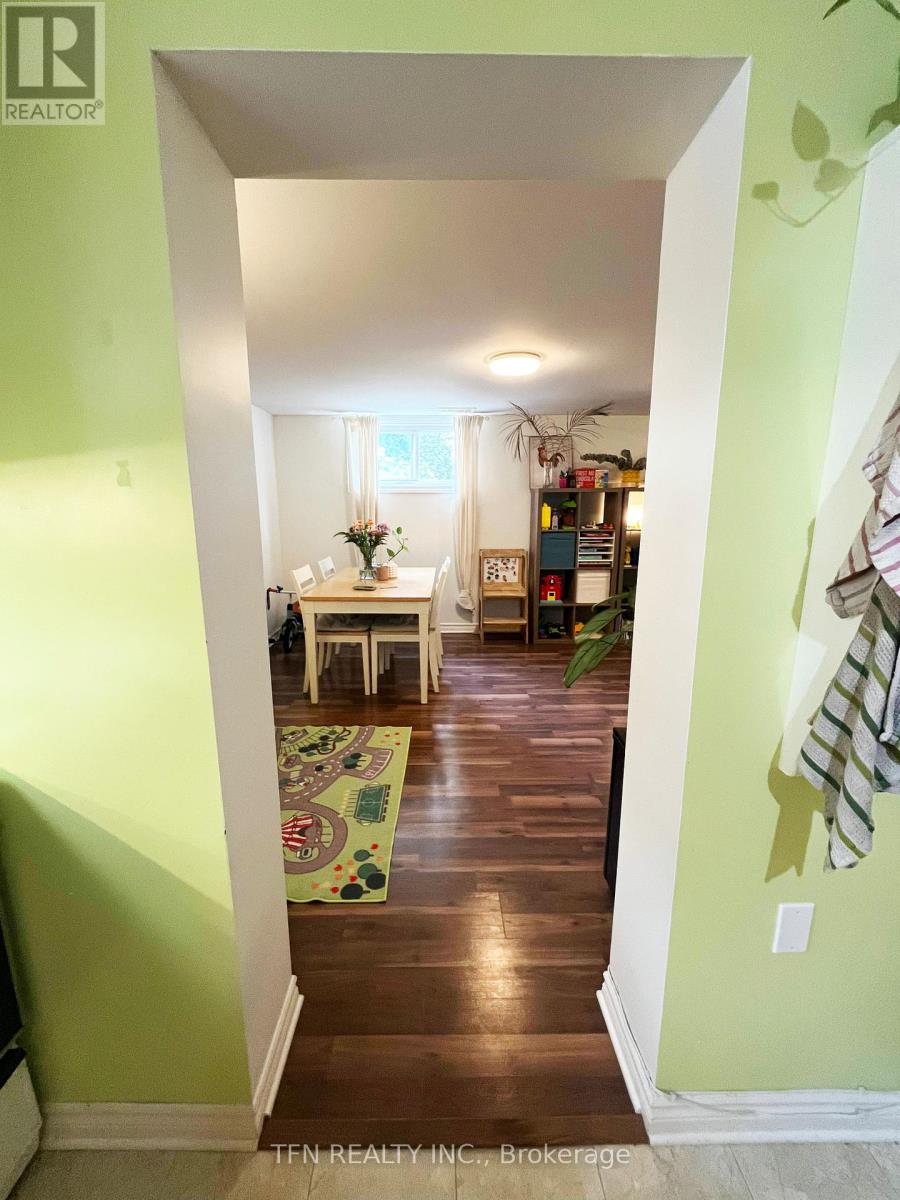 A hallway with a green wall and a white doorway leading to a dining room.