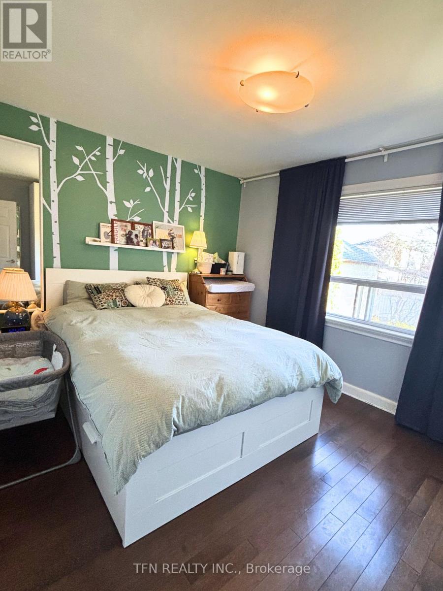 A bedroom with a white bed and a green wallpaper.