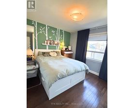 A bedroom with a white bed and a green wallpaper.