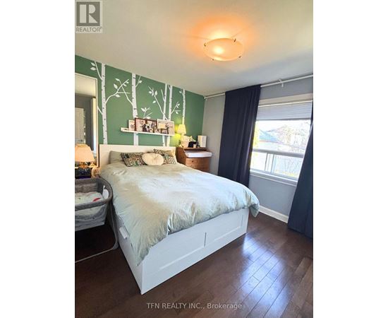 A bedroom with a white bed and a green wallpaper.