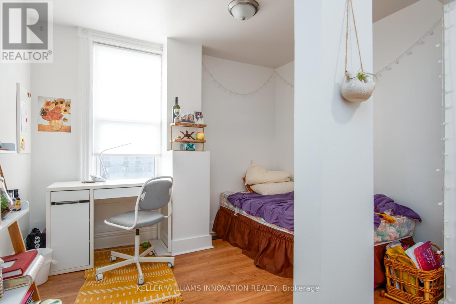 A bedroom with a bed, desk, and chair.