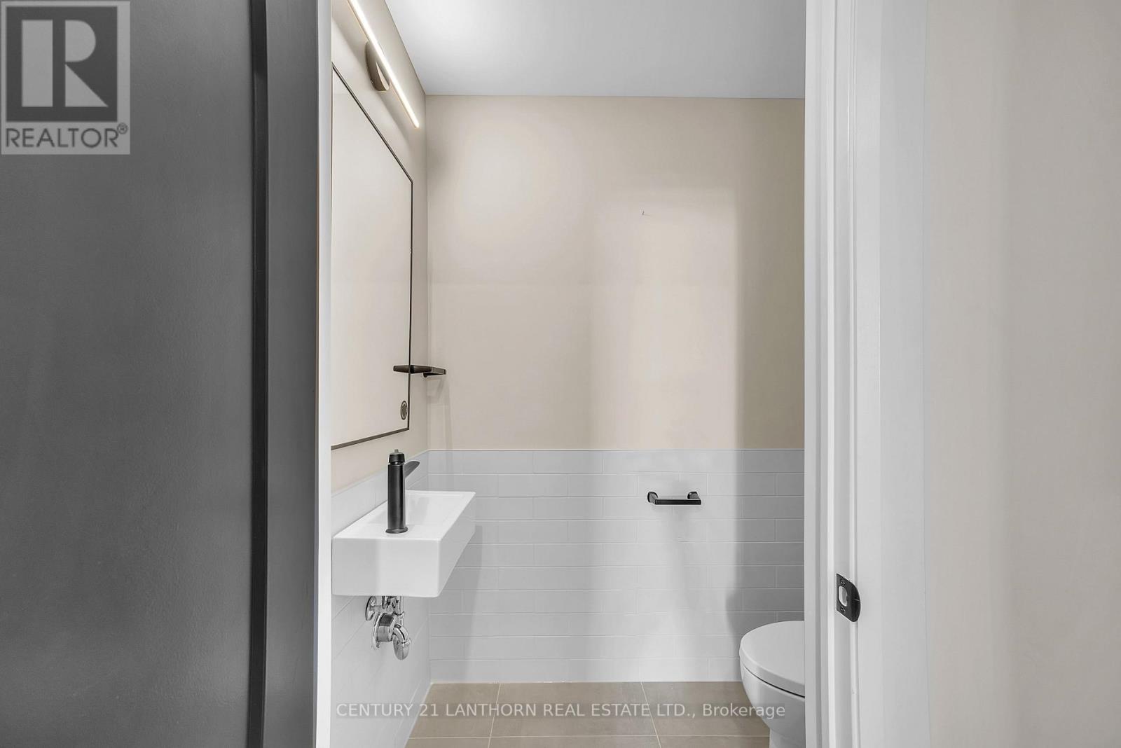 A bathroom with a sink, mirror, and toilet.