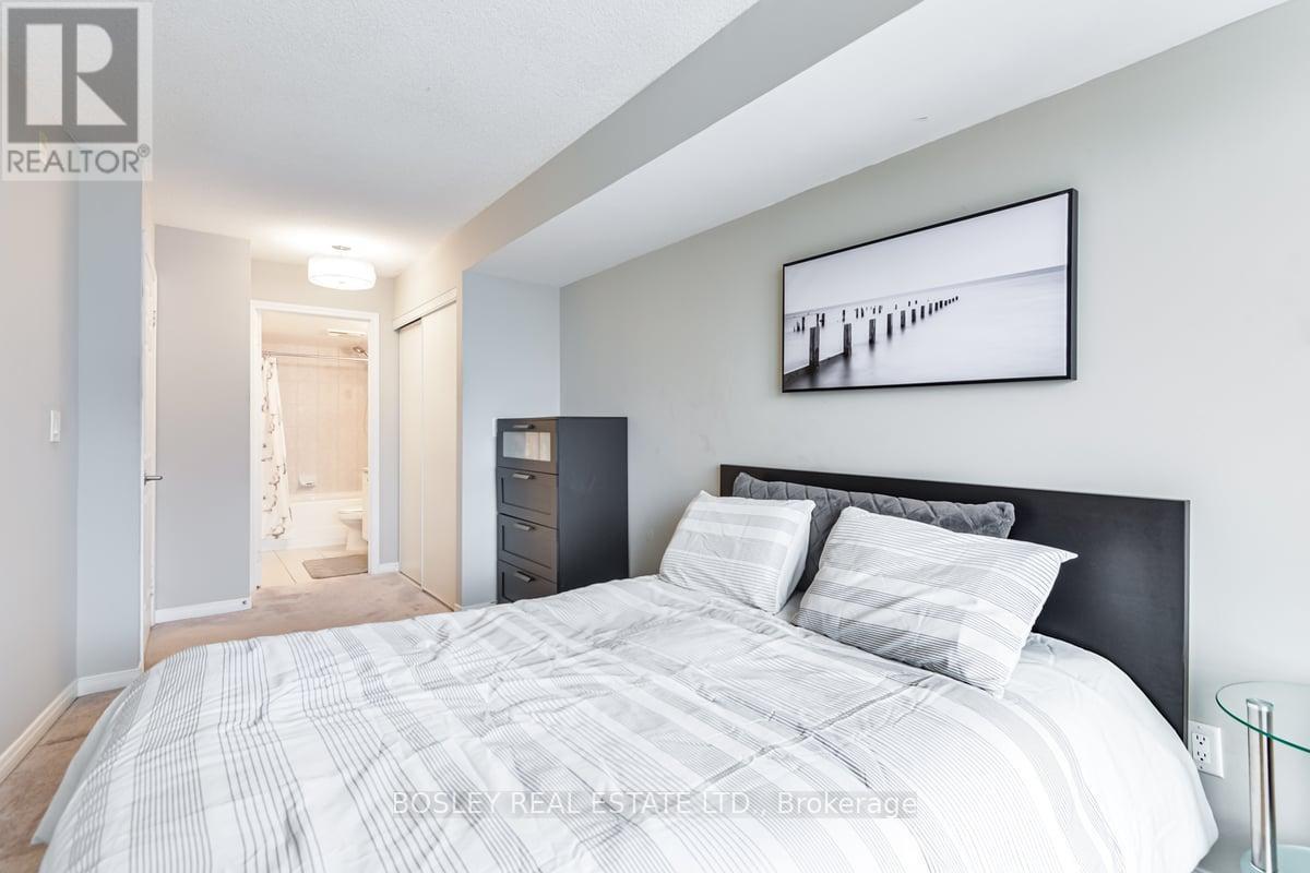 A bedroom with a large bed and a painting on the wall.
