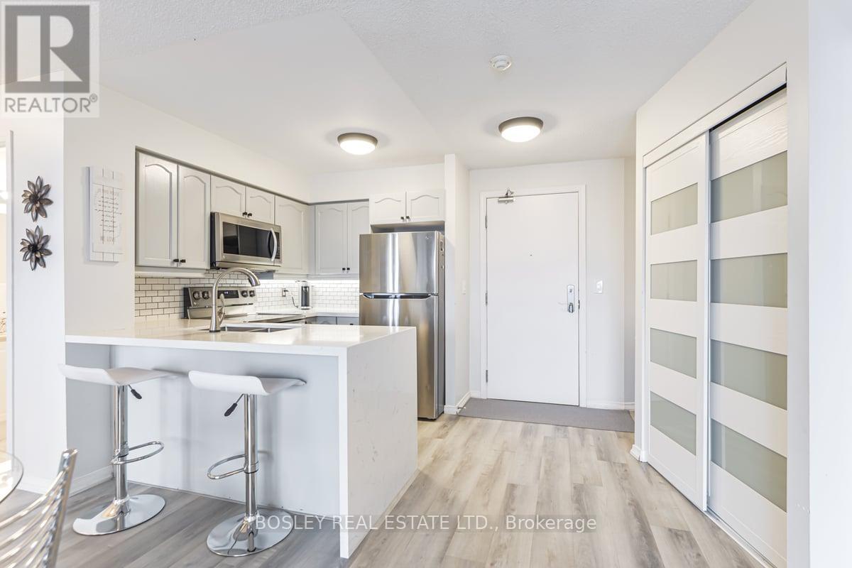 A modern kitchen with white cabinets and a bar area.