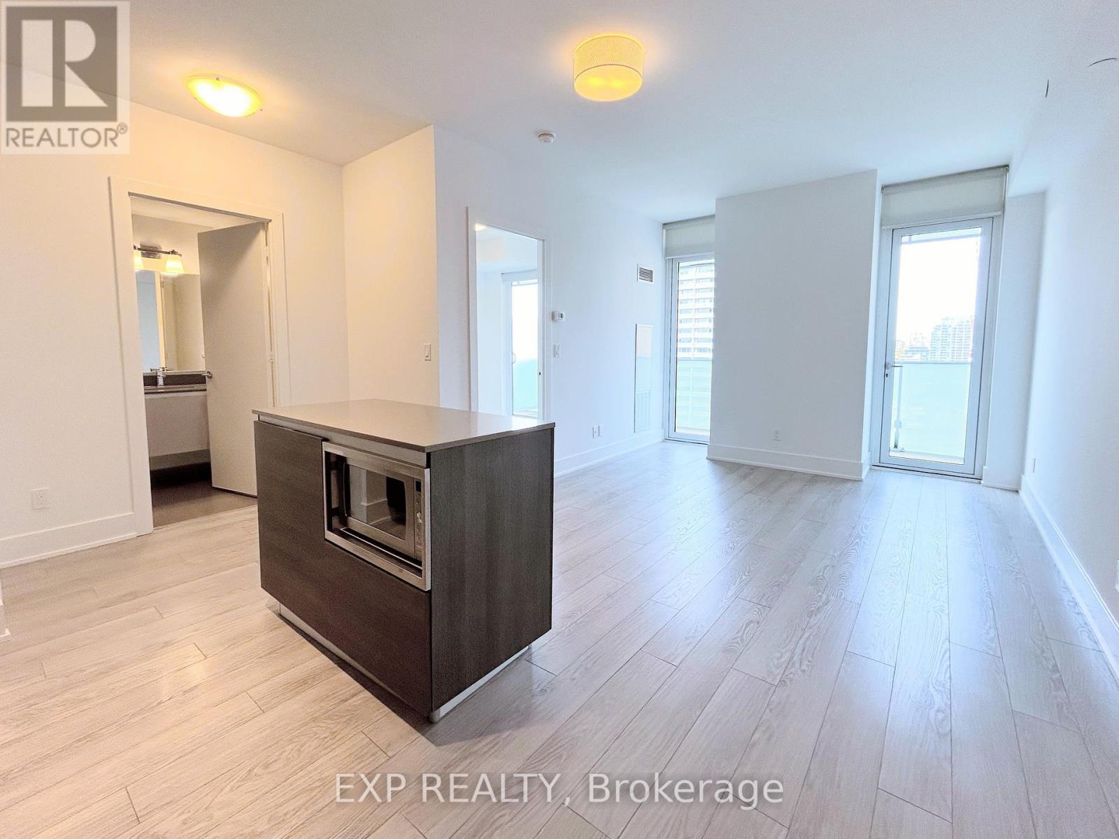 A spacious room with a built-in oven and wooden flooring.