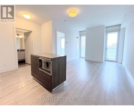 A spacious room with a built-in oven and wooden flooring.