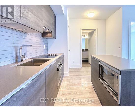 A modern kitchen with a sink and a stove top oven.