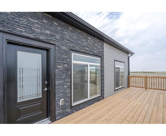 A house with a black door and a wooden deck.