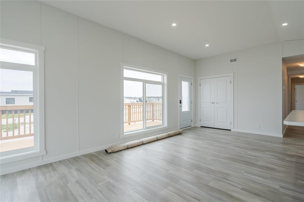 A spacious room with wooden flooring and white walls.