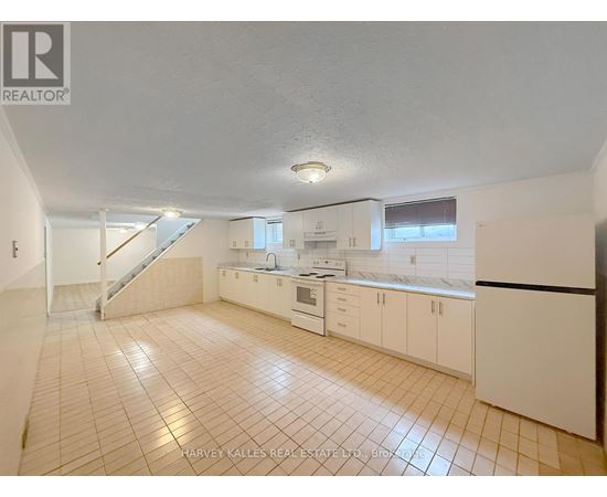 A kitchen with white cabinets and a tiled floor.